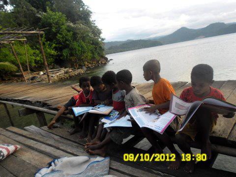 Anak-anak SD Kampung Tablasupa sedang membaca buku-buku bacaan dan pelajaran dari kegiatan BakSos Madridista Jayapura